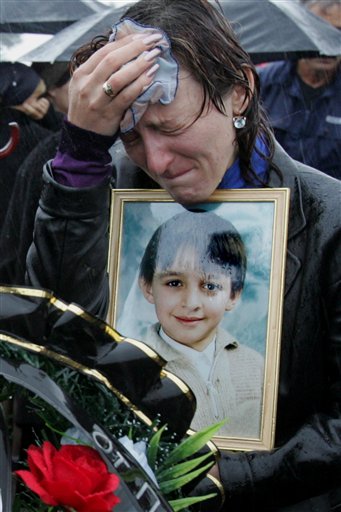 The mother of Zaur Gutnov, 11, who was killed in the school seizure, weeps over his portrait during his funeral in Beslan, Russia Monday Sept. 6, 2004. (AP)