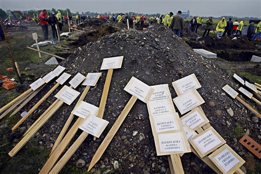 Wooden planks, temporary grave markers, bearing names and dates of school hostag victims are prepared for before their funerals in Beslan, Russia Monday Sept. 6, 2004. (AP)