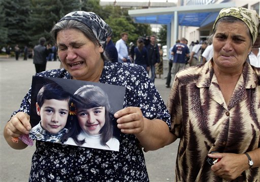 Women weep as they carry a photo of children during the funeral of school seizure victims, Beslan, Sunday Sept. 5, 2004. (AP)