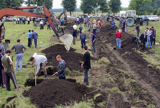 Beslan residents dig graves for those killed during a school assault, Beslan, Sunday Sept. 5, 2004. (AP)