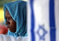 July 11, 2007: A Sudanese refugee stands behind an Israeli flag at a park near the Israeli Parliament building in Jerusalem, during a rally asking the Israeli government for assistance. (AFP)